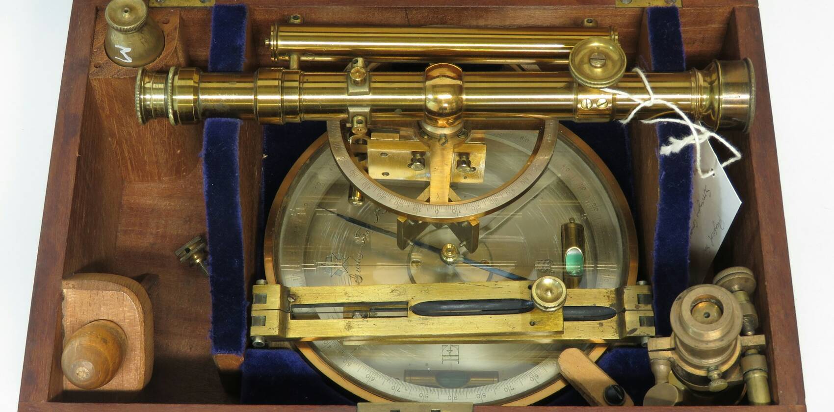An antique brass surveying instrument in its fitted wooden case