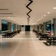 An empty school canteen with rows of benches and tables